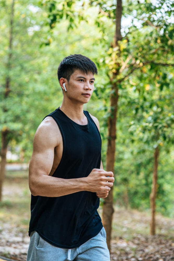 Man exercising outdoors with greenery in the background