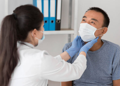 Doctor examining a patient's throat (specifically thyroid gland size), in an doctor's clinic.