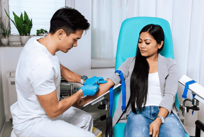 phlebotomist extracting blood sample to patient
