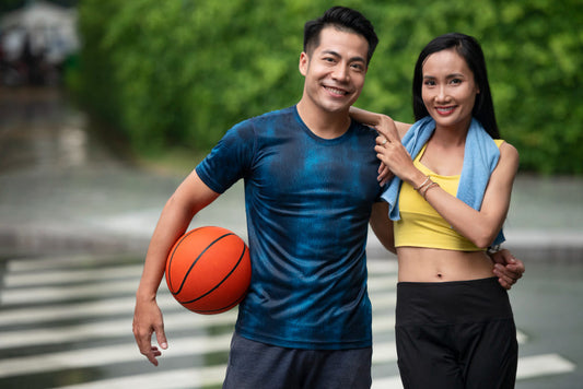 Man and woman after a workout with a basketball and towel, standing on a street.