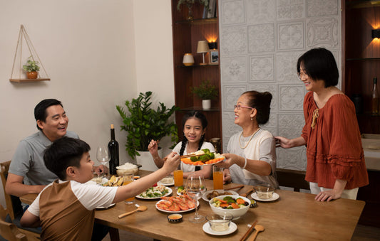 Family of five gathered around a dinner table in a modern kitchen, enjoying a meal together.