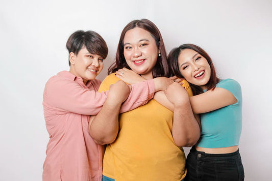 Three women posing together against a white background