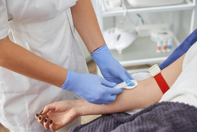 Person receiving a blood test with a nurse in a medical setting