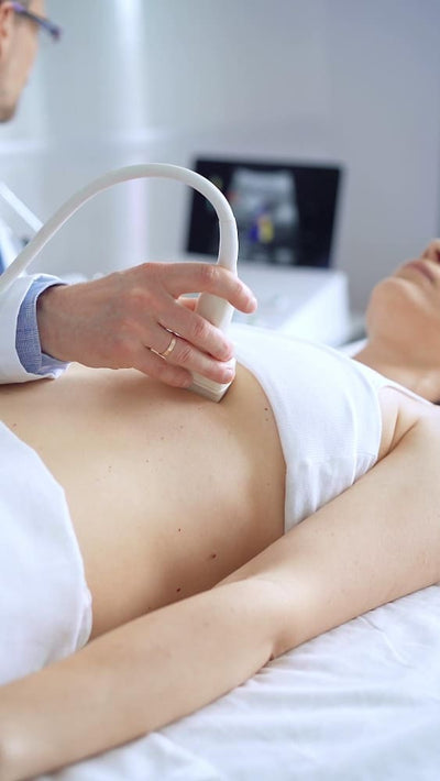 Patient receiving an breast ultrasound examination on a medical bed.