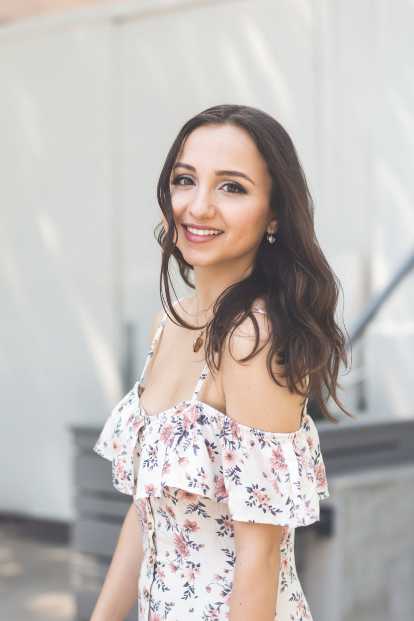 Woman wearing a floral off-shoulder top with a blurred background